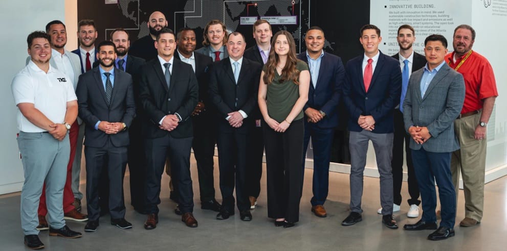 Um grupo de participantes do STEP em trajes sociais posa para uma foto em um escritório da TKE.
